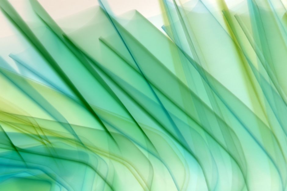 A dynamic abstract image of green and blue flowing waves creating a vibrant and futuristic feel.